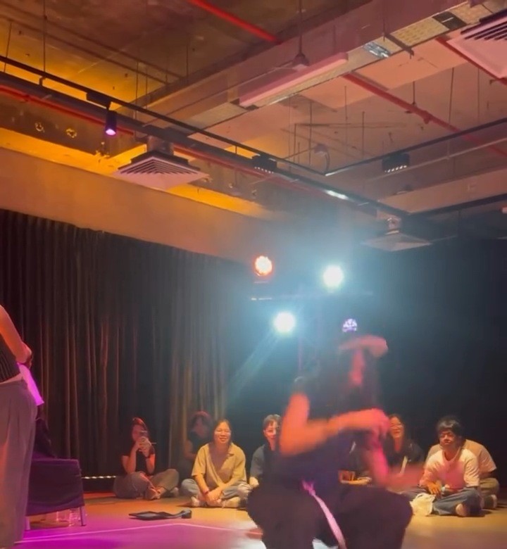 A dancer battling in a studio cypher as the crowd watches
